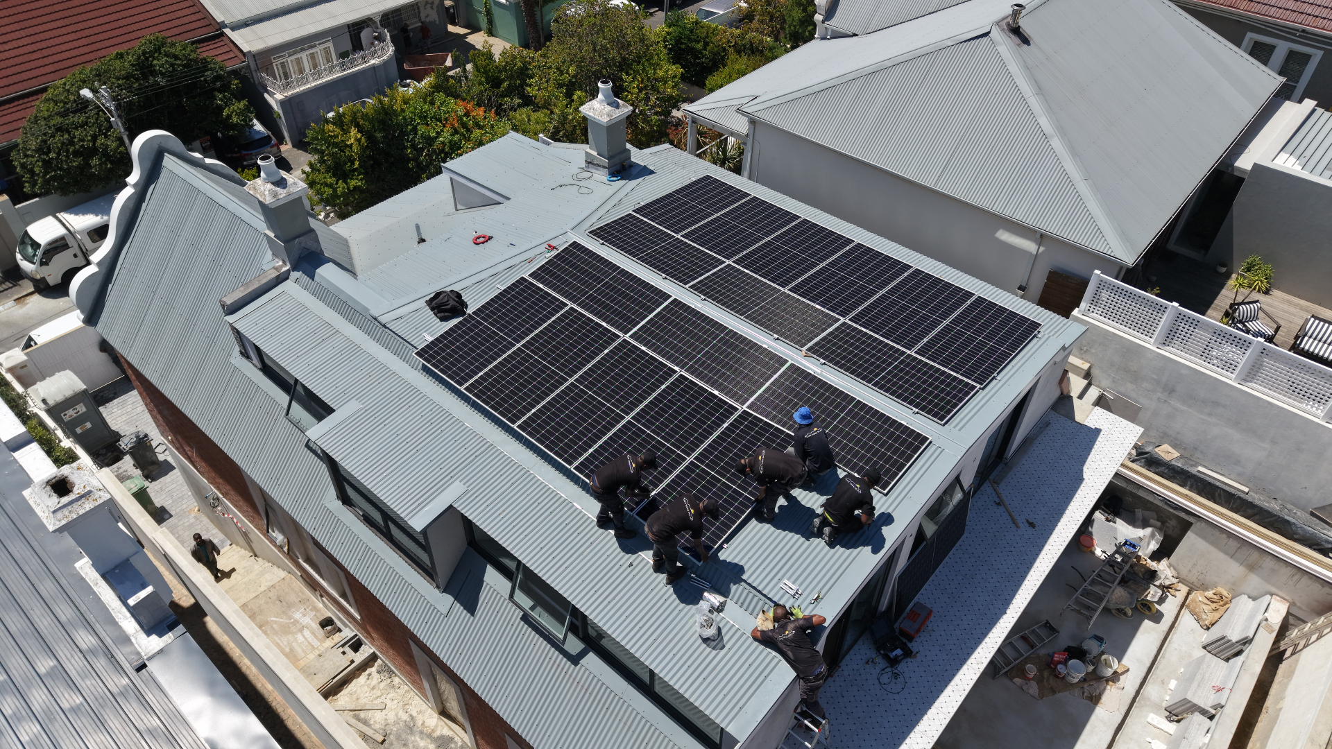 Drone view of Aiko solar panels on a light corrugated metal roof of a Cape Dutch-style home in Greenpoint